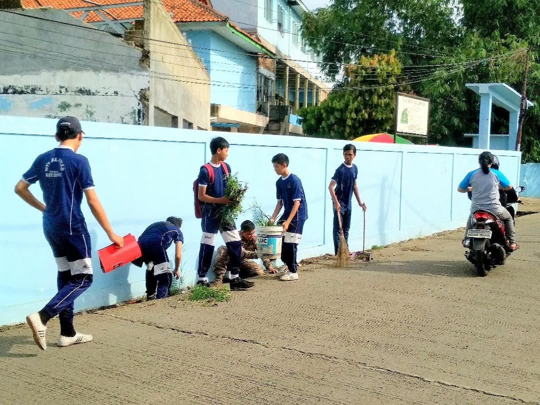 Siswa MTs Al-Jihad Cilodong Depok bersihkan sampah di saluran air di pagar pintu masuk sekolah