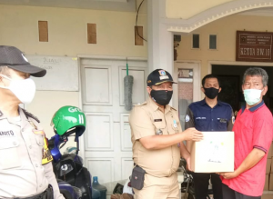 Lurah Bintaro, Satya (tengah) secara simbolis memberkan Bansos kepada Ketua RW 10