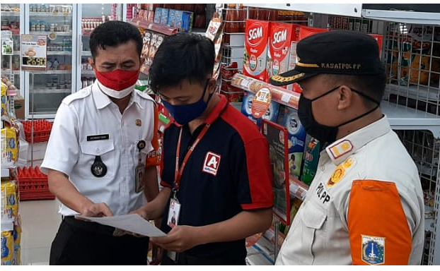 tampak Lurah Karet Semanggi, Achmad Yani, S. Sos (kiri) sedang memeriksa kelengkapan perizinan