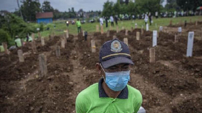 Petugas Petugas menguburkan jenazah di TPU Srengseng Sawah, Jakarta.