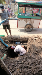 Para pekerja sedang memperbaiki Pipa PDAM yang pecah.