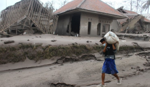 Seorang warga mengangkut barang yang bisa diselamatkan dari rumahnya yang hancur akibat erupsi gunung Semeru yang meluncurkan awan panas di desa Supiturang, Lumajang, Jawa Timur, Minggu (5/12/2021).