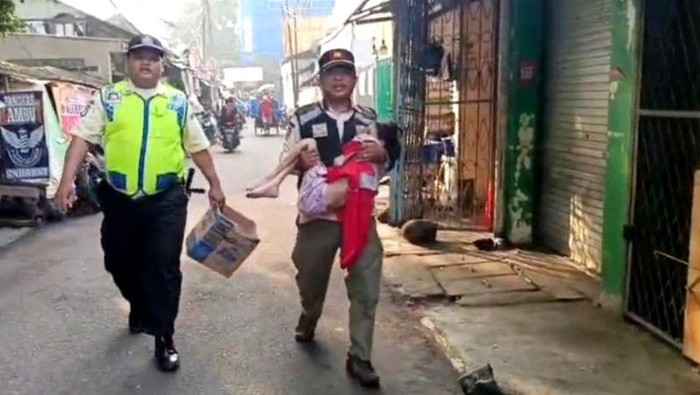 Satpol PP Kebayoran Lama mengamankan seorang anak yang diduga disiksa oleh orang tuanya di Pasar Kebayoran Lama
